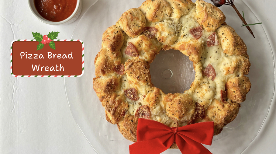 Pizza bread in the shape of a wreath, with a red bow at the bottom.